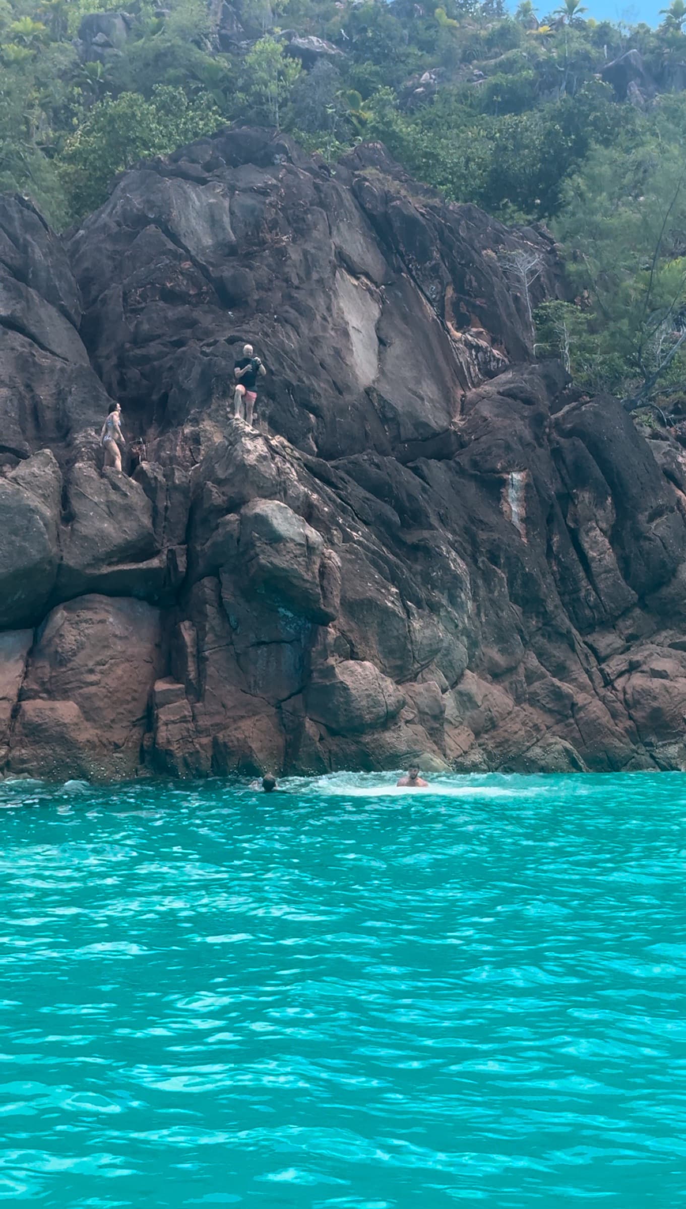 Cliff jumping into the turquoise inner-island sea, Seychelles